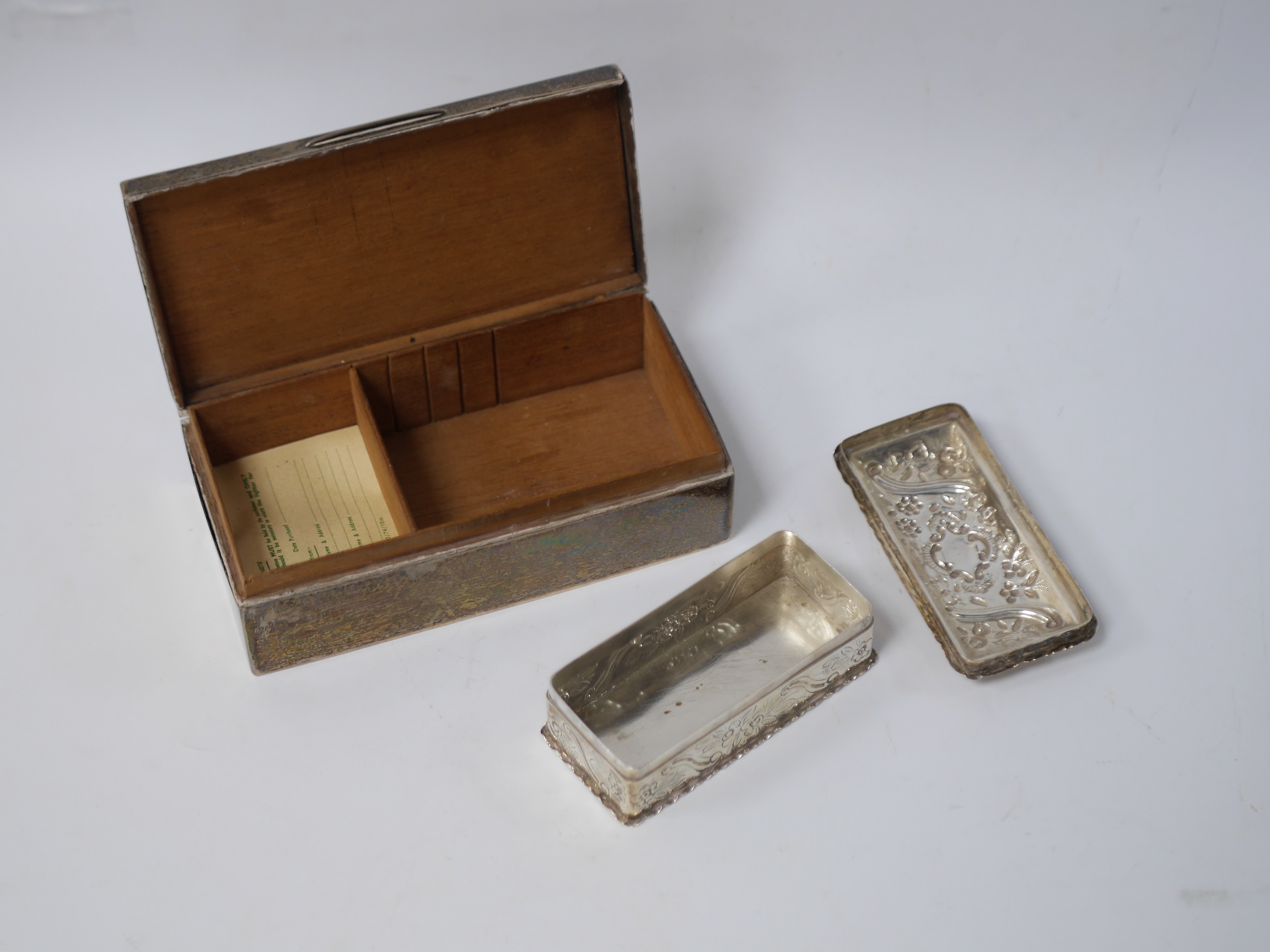 A late Victorian silver sugar caster, Holland, Aldwinckle & Slater, London, 1899, 19.3cm, a silver mounted cigarette box, a late Victorian repousse silver trinket box and cover by William Comyns and a George V silver gob